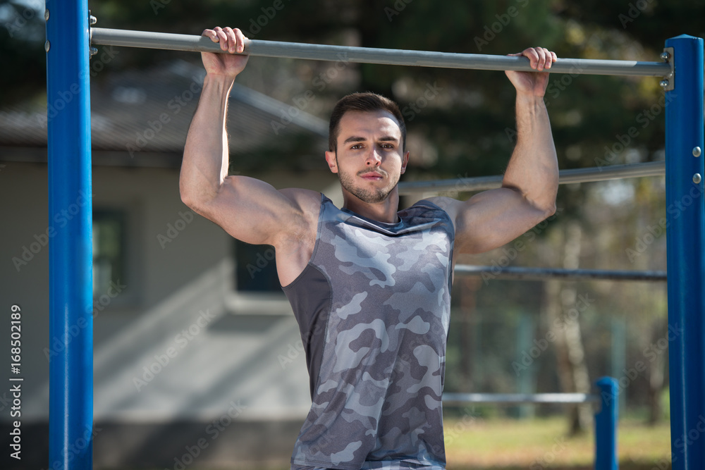 Young Athlete Exercising With Dips Bar