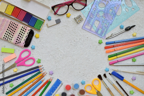 Frame of School supplies: pencils, markers, paints, pens on a light background. Back to school. View from above. Flat lay