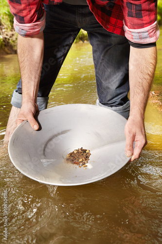 Contemporary lucky prospector found lot of gold in creek when panning sand