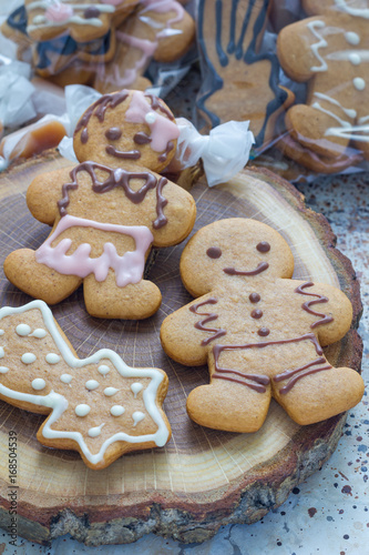 Sweet gifts for holiydays. Homemade christmas gingerbread cookies and caramel candies on a wooden board, vertical