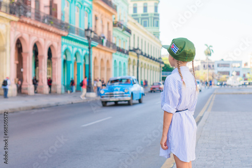 Little girl in popular area near El Capitolio in Havana City, Cuba. Portrait of kid background vintage classic american car
