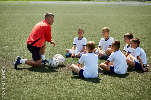 Coach Instructing Junior Football Team