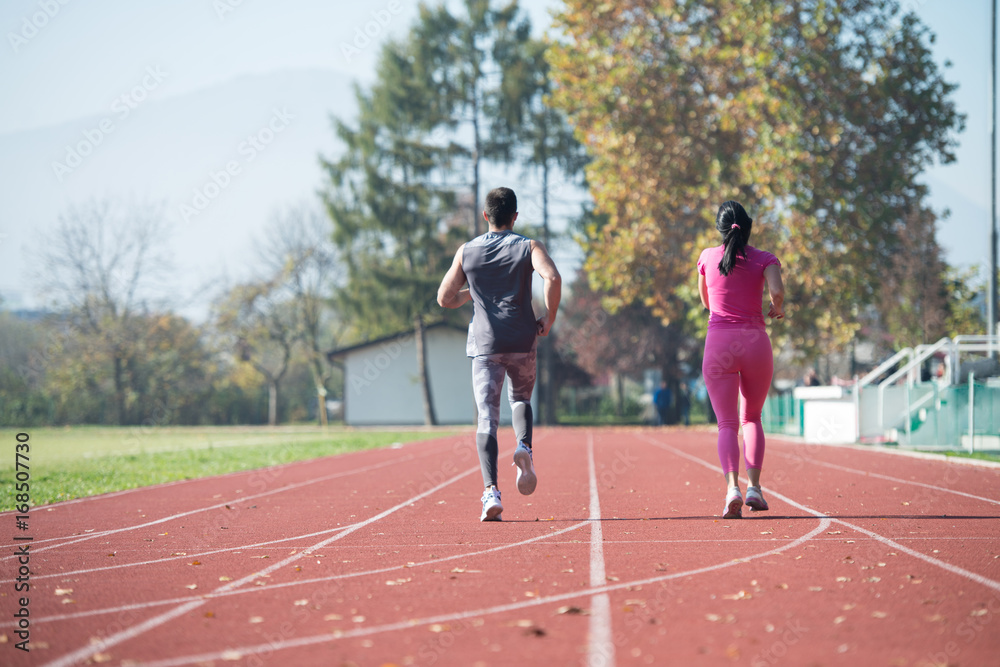 Athletic Couple Sprinting on the Running Track