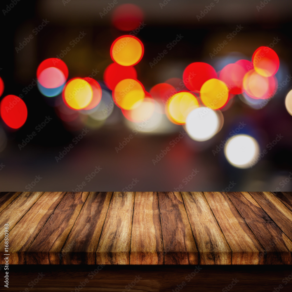 Empty wood table with abstract blurred restaurant lights background.