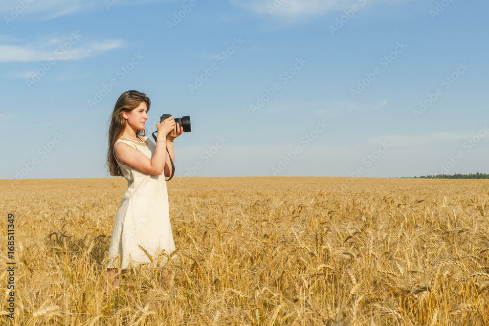 Pretty girl taking photos with big black camera on the field Pretty girl taking photos with big black camera on the field