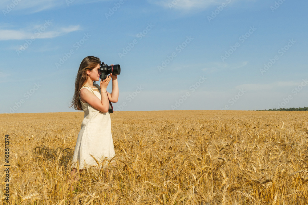 Pretty girl taking photos with big black camera on the field Pretty girl taking photos with big black camera on the field