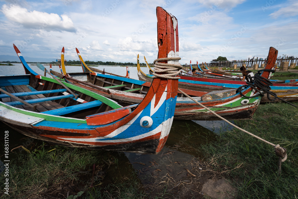 Traditional painted boats at U Bein Bridge at Taungthaman Lake, Mandalay, Myanmar