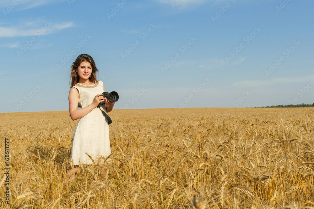 Pretty girl taking photos with big black camera on the field Pretty girl taking photos with big black camera on the field