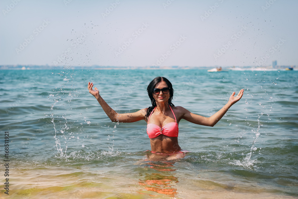 portrait of happy sexy girl in pink bikini posing against sea portrait of happy sexy girl in pink bikini posing against sea