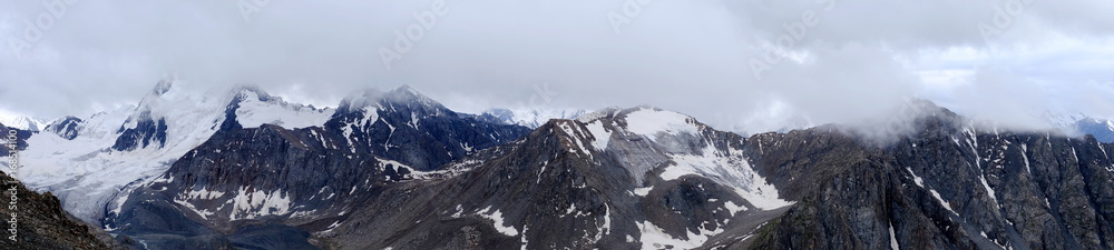 Panorama of mountain peaks in the clouds