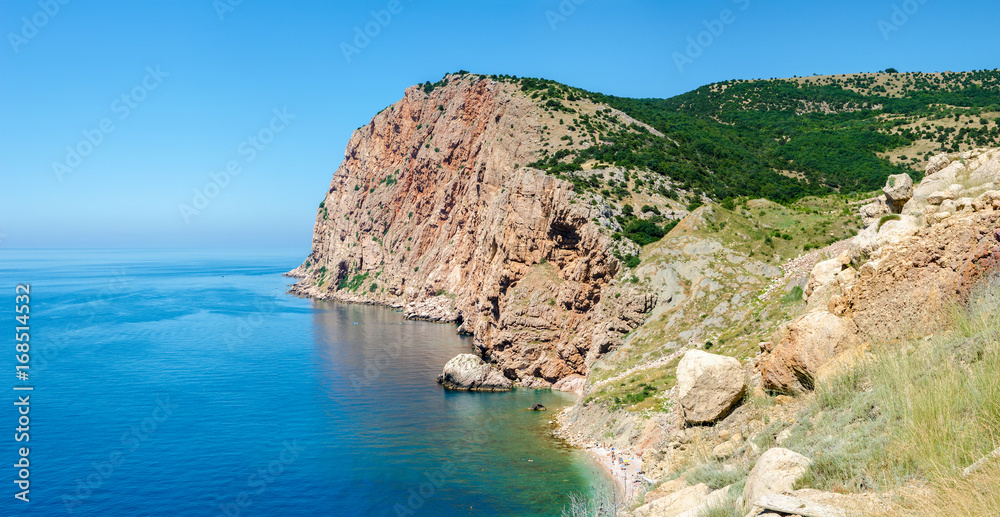 Rocky shore coast of tropical azure sea. The Black Sea, Crimea. Hot, sunny summer day