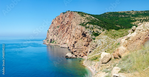 Rocky shore coast of tropical azure sea. The Black Sea, Crimea. Hot, sunny summer day