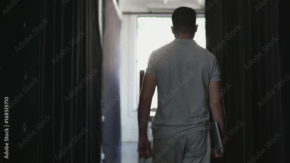Rear view of a young man walking to his office Rear view of a young man walking to his office
