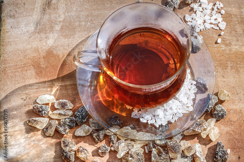 Tasse Tee mit Kandiszucker auf einer Terrakottaplatte photo