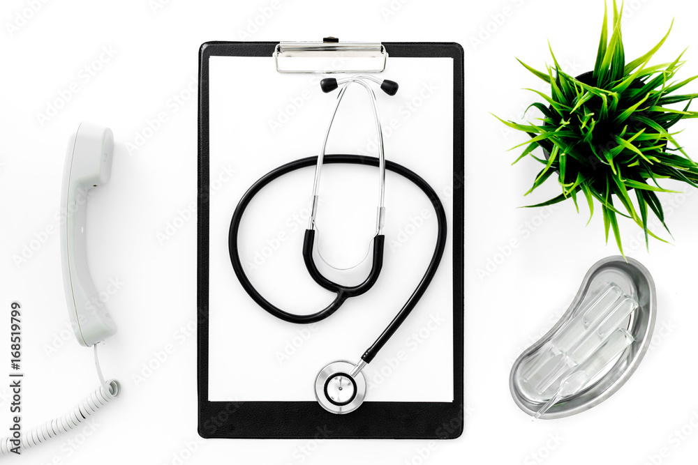 Fototapeta premium Call doctor. Phone, clip pad, stethoscope and cuvette with ampoulie on white background top view