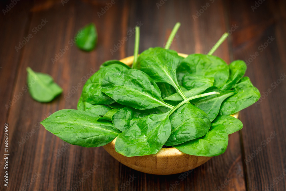 Fresh juicy spinach leaves on a wooden brown table. Natural products, greens, healthy food, vitamins. Fresh juicy spinach leaves on a wooden brown table. Natural products, greens, healthy food, vitamins.