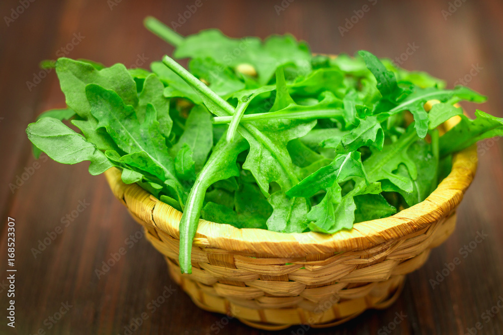 Fresh juicy leaves of arugula on a brown wooden table. Fresh juicy leaves of arugula on a brown wooden table.