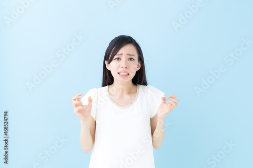 怒り・女性・ブルーバック