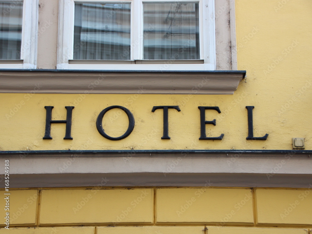 Black Hotel Text Sign on Yellow Building Black Hotel Text Sign on Yellow Building