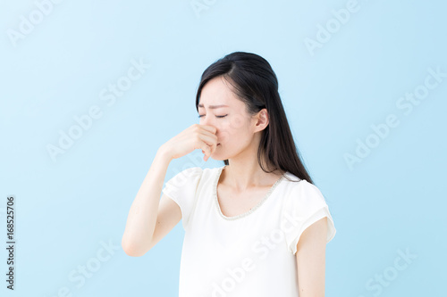 鼻を摘む女性・ブルーバック photo