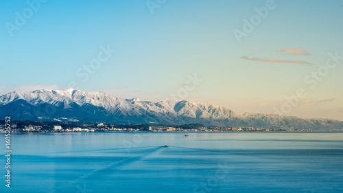 Fototapeta Naklejka Na Ścianę i Meble -  The largest freshwater Biwa Lake, Shiga, Kyoto, Japan in winter. Fantastic freshwater lake scene, snow covered mountain and bright clear blue sky background.