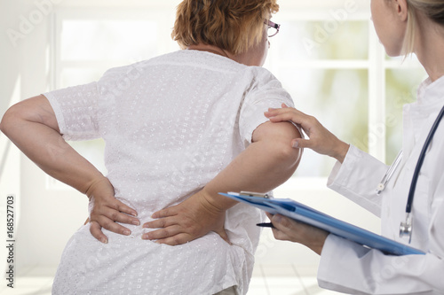 Senior woman with back pain. Osteopathy, Alternative medicine, pain relief concept. Physiotherapy, sport injury rehabilitation photo