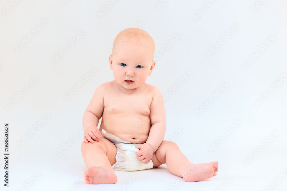 A happy baby is smiling on a light background. A cute boy. Emotions of a young child A happy baby is smiling on a light background. A cute boy. Emotions of a young child