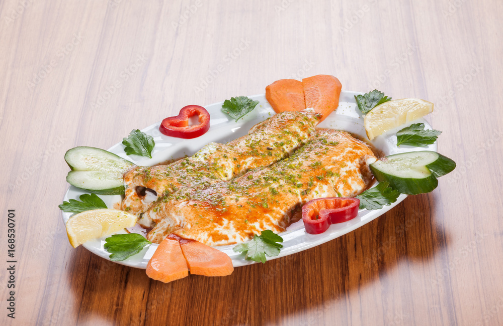 Turkish kebab (beyti) served with yoghurt and vegetables on wooden table Turkish kebab (beyti) served with yoghurt and vegetables on wooden table