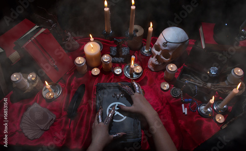 Fotografia Witchcraft composition with witch's hands, satanic magic books, skull, candles, tarot cards, crystal and amulets