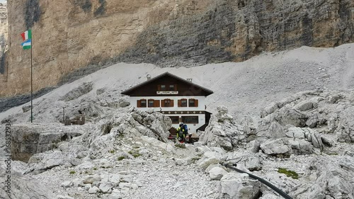 Mountaineers in front of Giussani Mountain Hut at the foots of Tofana wall, Dolomites, Cortina d'Ampezzo, Italy photo