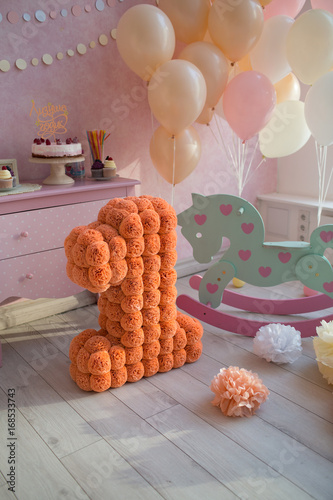 The child is one year old. room decorated with balloons with a gift cake, a toy horse and a large number one of colored paper. photo