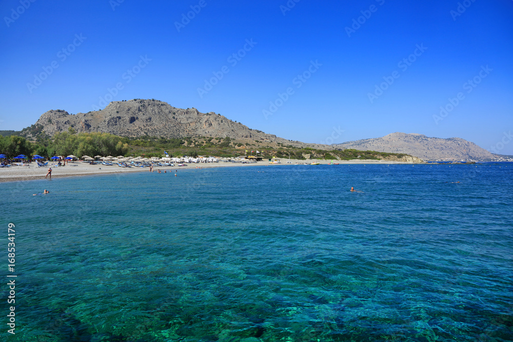 Przepiękna, czysta i błękitna woda morza Śródziemnego, wybrzeże, plaża, parasole, hotele.