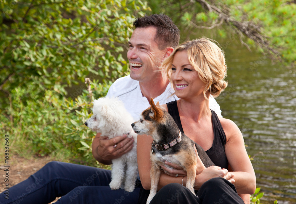 beautiful couple with dogs at lake