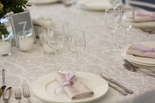 Beautiful table setting with crockery and flowers for a party, wedding reception or other festive event. Glassware and cutlery for catered event dinner. © Angelov