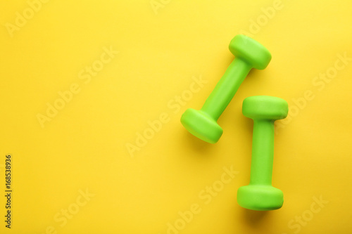 Green dumbbells on yellow background