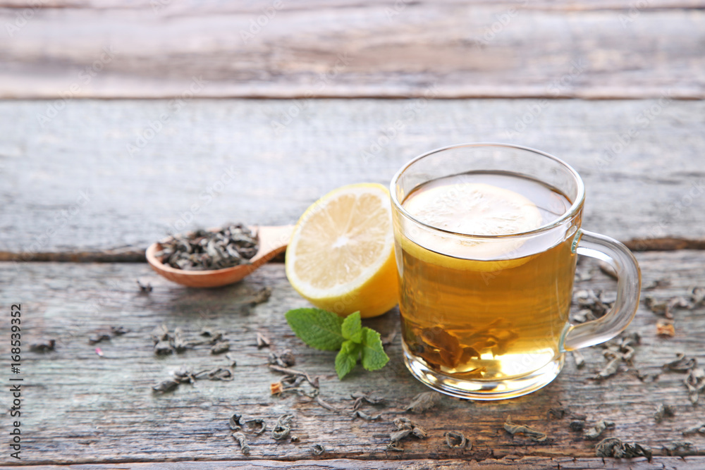 Cup of tea with lemon and mint on wooden table Cup of tea with lemon and mint on wooden table