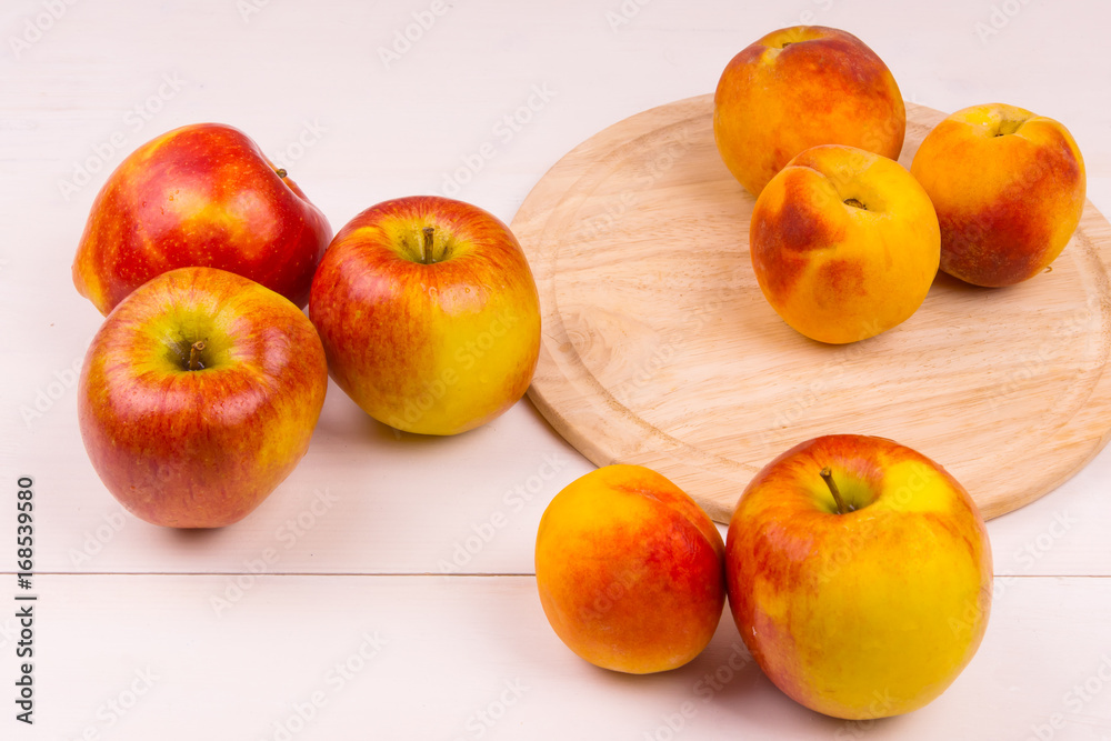 Ripe apples and peaches on a wooden table. Ripe fruit on a light background Ripe apples and peaches on a wooden table. Ripe fruit on a light background