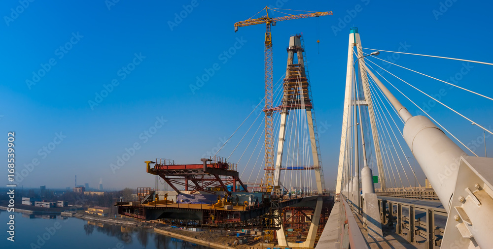 Construction of a cable-stayed bridge across the river.