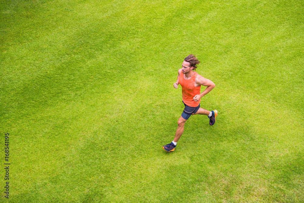 Jogging man training cardio morning run routine on grass park summer. Running runner active lifestyle - View from above. Jogging man training cardio morning run routine on grass park summer. Running runner active lifestyle - View from above.