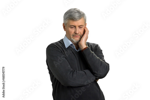 Worried mature man on white background. Upset senior man with lower eyes thinking against white background. Deep thoughts in searching right decision.