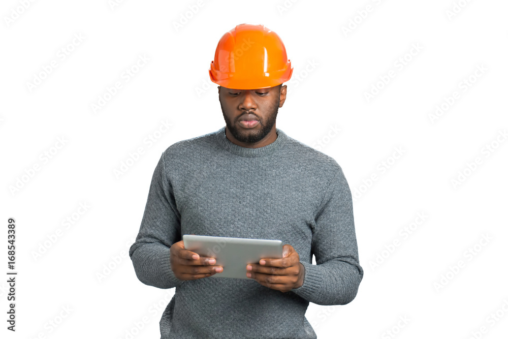 Male engineer looking at computer tablet. Afro american young architect hold computer tablet on white background. Checking some information. Male engineer looking at computer tablet. Afro american young architect hold computer tablet on white background. Checking some information.