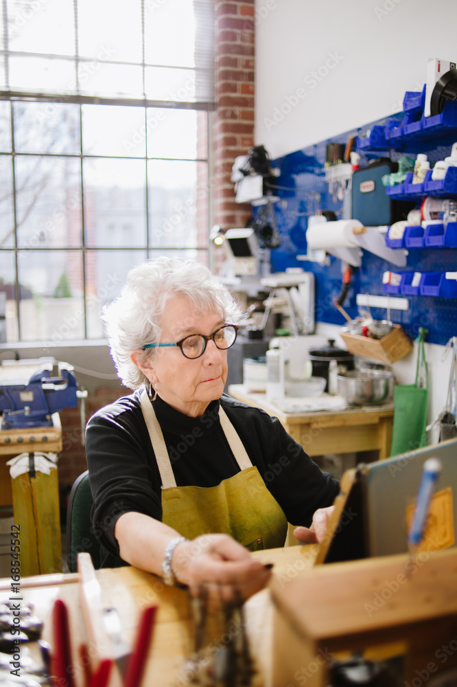 Art Jeweler on tablet computer in studio Art Jeweler on tablet computer in studio