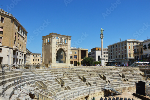 Roman amphitheater with palaces of the Sedile and the INA (Istituto Nazionale delle Assicurazioni) palace in Sant'Oronzo square in Lecce, Apulia, Italy photo