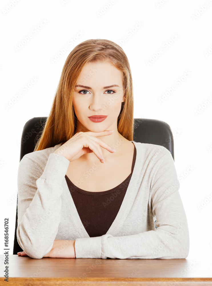 Beautiful casual woman sitting by a desk. Beautiful casual woman sitting by a desk.