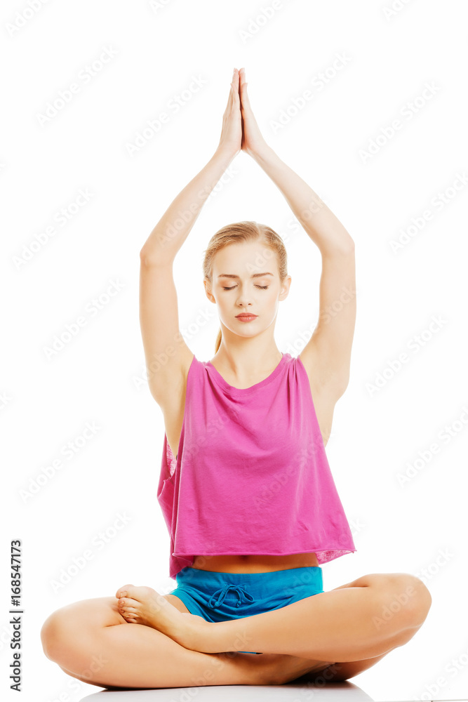 Beautiful young caucasian woman is exercising, doing yoga.