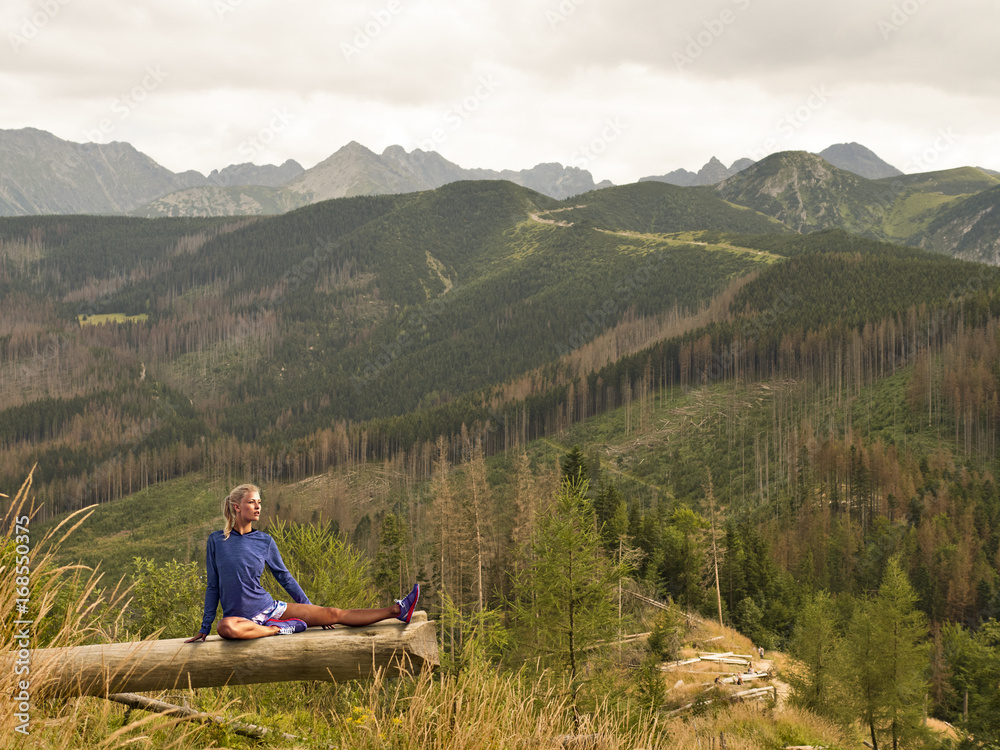 Girl practicing yoga in the mountains. Gymnastics on a log Girl practicing yoga in the mountains. Gymnastics on a log