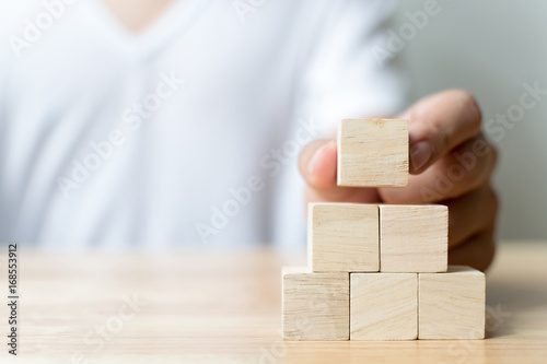 Hand arranging wood block stacking as step stair. Business concept for growth success process photo