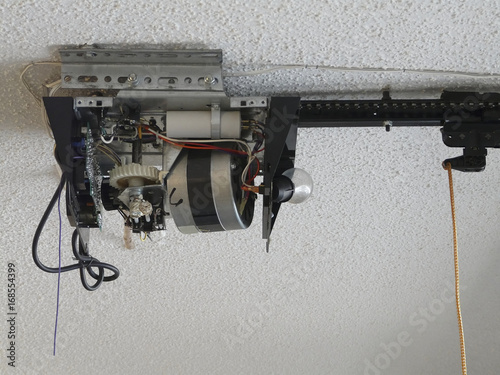 Принти на полотні Close-up of an automatic garage door opener motor gear drive needing repair at a residence