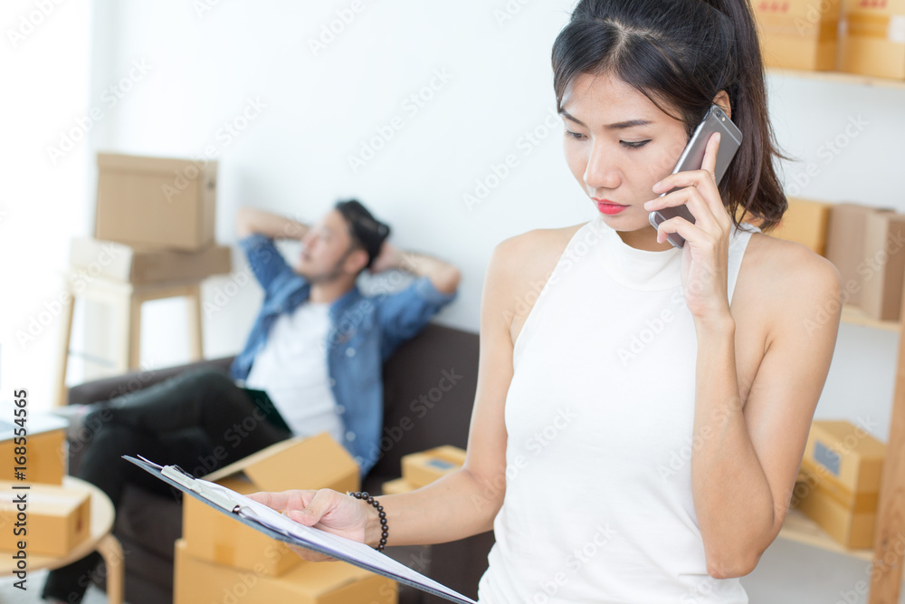 Young Asian Woman using Smartphone for Concact to Customer, Young Owner Woman Start up for Business Online, SME, Delivery Project, Woman with Online Business or SME Concept. Young Asian Woman using Smartphone for Concact to Customer, Young Owner Woman Start up for Business Online, SME, Delivery Project, Woman with Online Business or SME Concept.