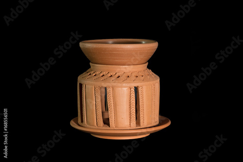 Isolated terracotta stove for aromatherapy on black background photo